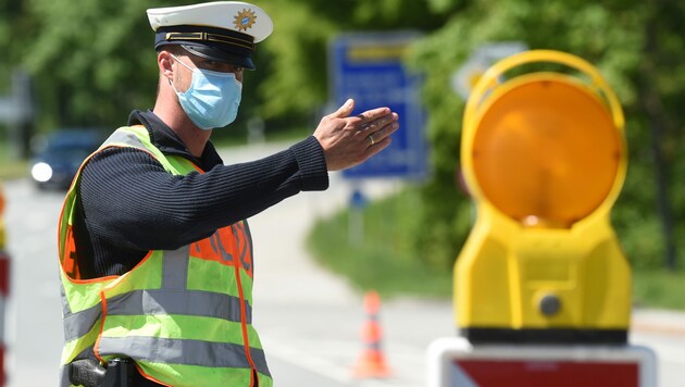 Ein deutscher Grenzpolizist winkt Einreisenden aus Österreich am Grenzübergang Kiefersfelden weiter. Es gibt nur mehr stichprobenartige Kontrollen. (Bild: APA/AFP/Christof STACHE)