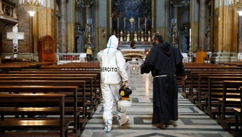 Ein Mitarbeiter der Armee mit einem Geistlichen in einer Kirche in Rom (Bild: LaPresse)