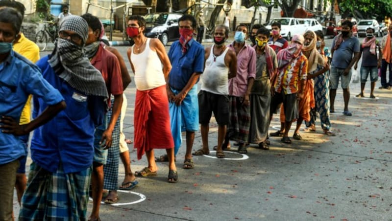 Diese Slumbewohner in Indien warten auf ihre Essensausgabe. (Bild: APA/AFP/Dibyangshu SARKAR)