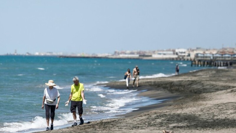 Spaziergänger am Strand von Ostia (Bild: APA/Cecilia Fabiano/LaPresse via AP)