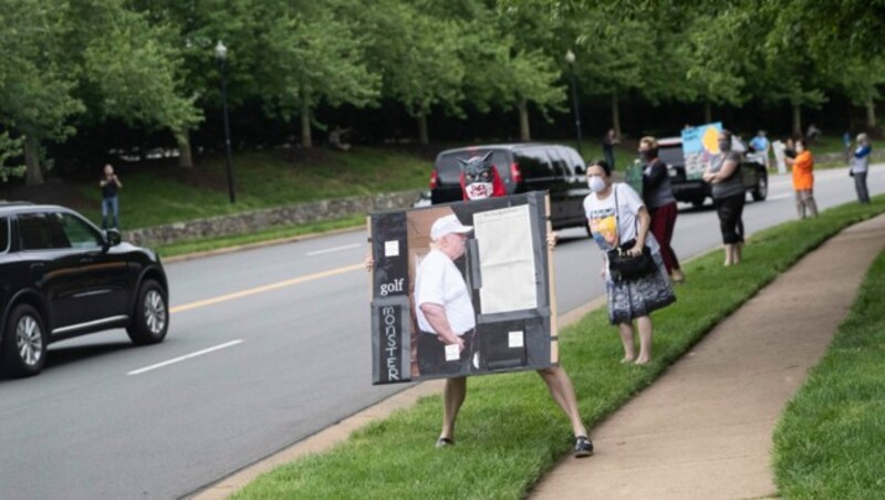 Aktivisten protestieren mit Abstand gegen Trumps Golf-Ausflug. (Bild: AP)