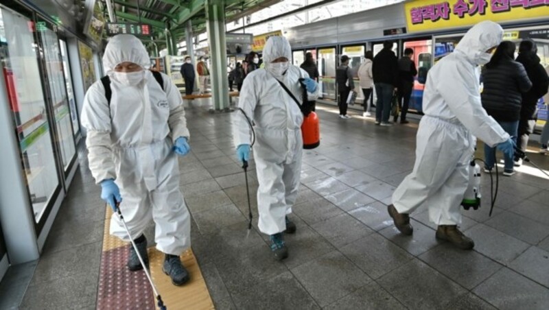 Mitarbeiter der Stadt Seoul sprühen Desinfektionsmittel auf den Bahnsteigen der U-Bahnen in Südkorea. (Bild: AFP )