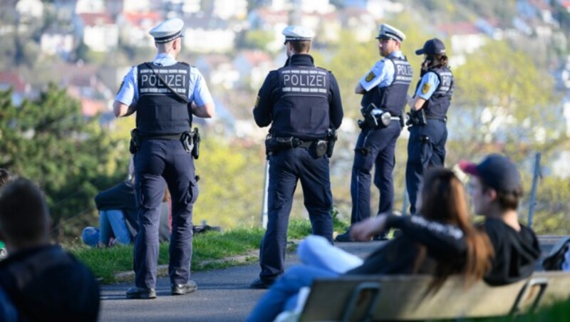 Polizeibeamte kontrollieren in einem beliebten Park im Süden Stuttgarts die Einhaltung der Vorschriften zur Eindämmung des Coronavirus. (Bild: APA/dpa/Sebastian Gollnow)