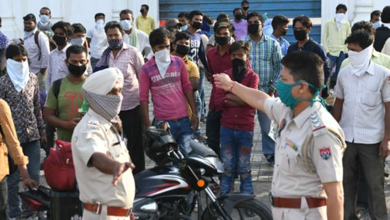 Die Polizei in Indien kontrolliert Gastarbeiter, die in ihre Heimatstädte am Land zurückkehren möchten. (Bild: AFP)