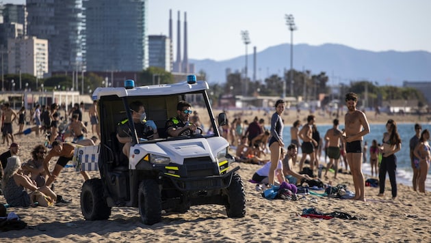 Die Polizei patrouilliert am Strand von Barcelona in Spanien. (Bild: AP)