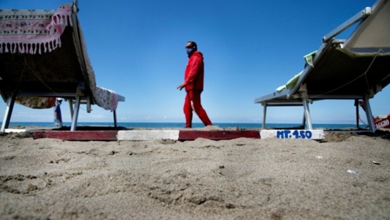 Ein Rettungsschwimmer überprüft den Abstand der Liegen am Strand. (Bild: AFP)