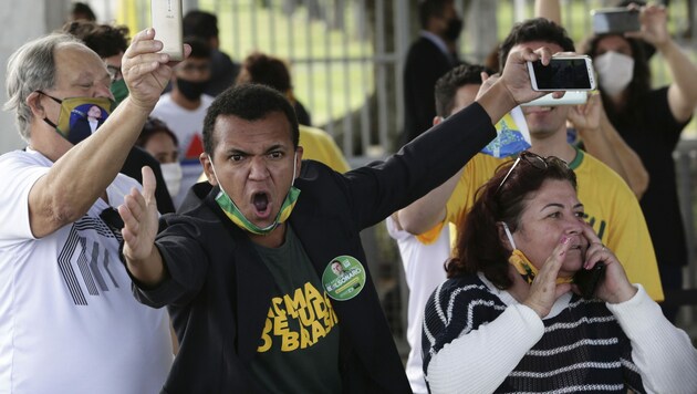 Unterstützer des brasilianischen Präsidenten Jair Bolsonaro beschimpfen Journalisten in der Hauptstadt Brasilia. (Bild: AP)