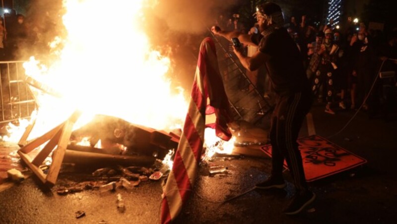 In der Nähe des Weißen Hauses in der Hauptstadt Washington zünden Demonstranten eine US-Flagge an. (Bild: AP)