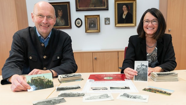 Die Historiker Peter Wiesflecker und Elisabeth Schöggl-Ernst vom Steiermärkischen Landesarchiv mit alten Ansichtskarten von der Riegersburg. (Bild: steiermark.at/Streibl)