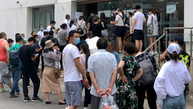 Bürger aus Peking stellen sich vor einem Gesundheitscenter an, um sich auf das neuartige Coronavirus testen zu lassen. (Bild: AP)