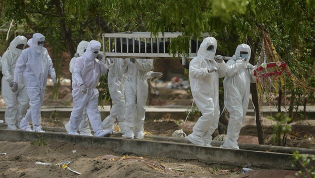 Freiwillige Helfer beerdigen einen Corona-Toten. (Bild: AFP)