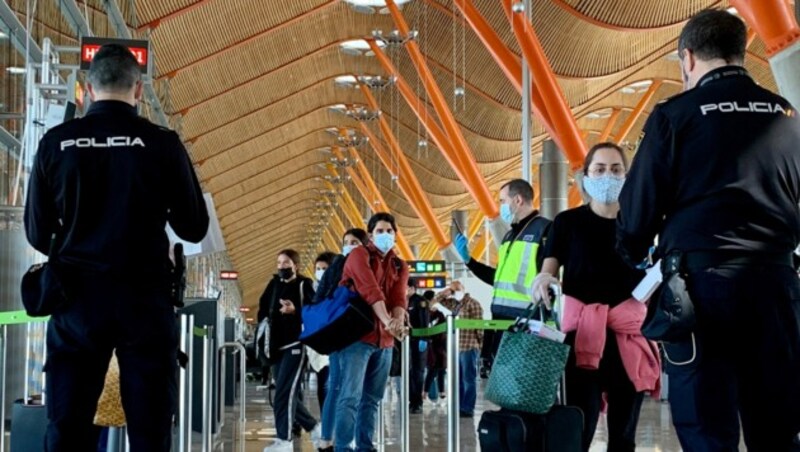 Polizisten überprüfen Passagiere, die von Paris nach Madrid geflogen waren. (Bild: AFP)