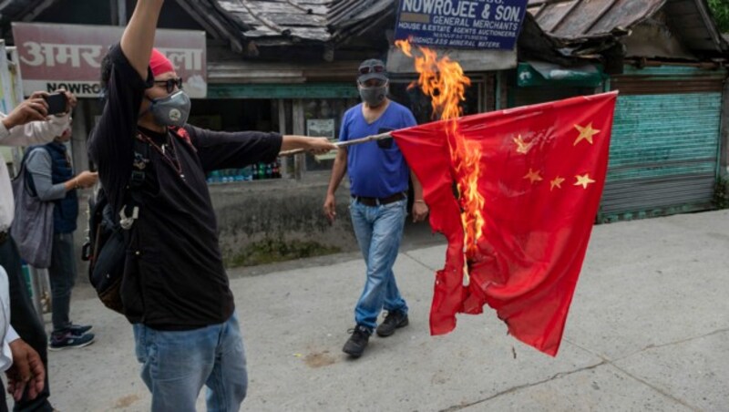 Ein tibetanischer Aktivist verbrennt eine chinesische Flagge als Zeichen des Protests gegen die chinesische Besatzung indischen Territoriums und Tibets. (Bild: AP)