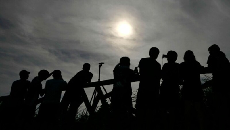 Neugierige verfolgen in Yonaguni, Okinawa (Japan) die Sonnenfinsternis. (Bild: AP)