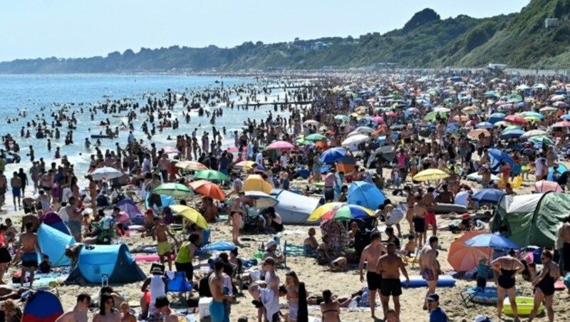 Auch am Strand sollte ausreichend Abstand gewahrt werden. Oben zeigt sich fast schon ein Musterbeispiel, die untere Variante ist hingegen problematisch. (Bild: AFP)