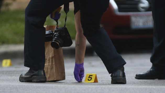 Ein Ermittler der Chicagoer Polizei beim Aufheben einer Patronenhülse. (Bild: John J. Kim/Chicago Tribune via AP)