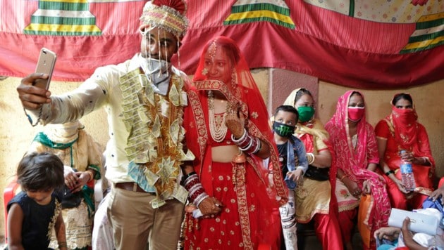 Ein indisches Brautpaar macht ein Selfie nach ihrer Hochzeit in Mumbai: Bei Hochzeitsfeiern sind in Indien derzeit maximal 50 Gäste erlaubt. (Bild: AP)