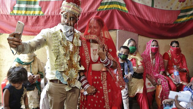 Ein indisches Brautpaar macht ein Selfie nach ihrer Hochzeit in Mumbai: Bei Hochzeitsfeiern sind in Indien derzeit maximal 50 Gäste erlaubt. (Bild: AP)