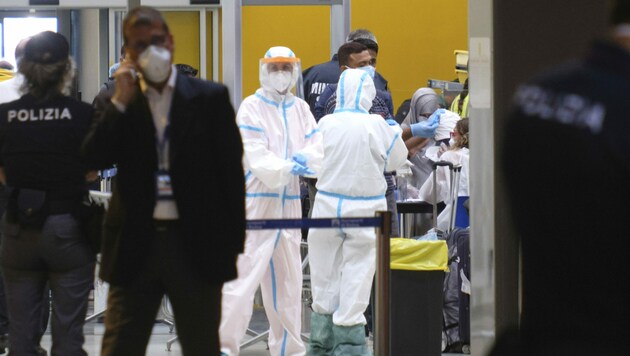 Mitarbeiter des italienischen Gesundheitsministeriums untersuchen Passagiere, die am Dienstag per Flugzeug aus Bangladesch in Rom gelandet sind. (Bild: AP)