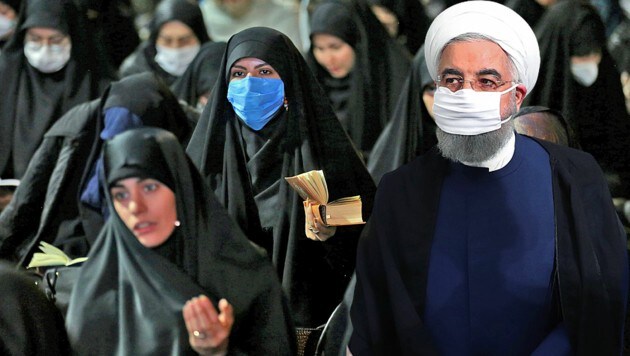 Präsident Hassan Rouhani befürchtet, dass bereits 30 Prozent der iranischen Bevölkerung mit dem Coronavirus infiziert sein könnten. (Bild: APA/AFP/ATTA KENARE, APA/AFP/Iranian Presidency, krone.at-Grafik)