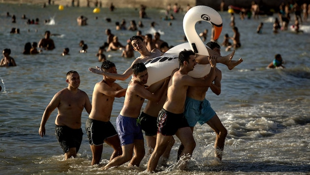 Touristen am Strand von Cadiz im Süden Spaniens. Aufgrund schlechter Nachrichten aus London könnte der Badespaß für englische Urlauber schon bald vorbei sein. (Bild: AP)