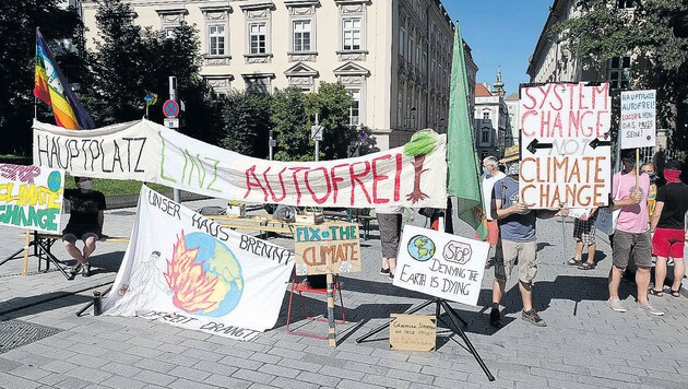 Die Aktivisten von „AUTOFREItag fürs Klima“ sperren den Linzer Hauptplatz für die Durchfahrt (Bild: Horst Einöder/ Flashpictures)