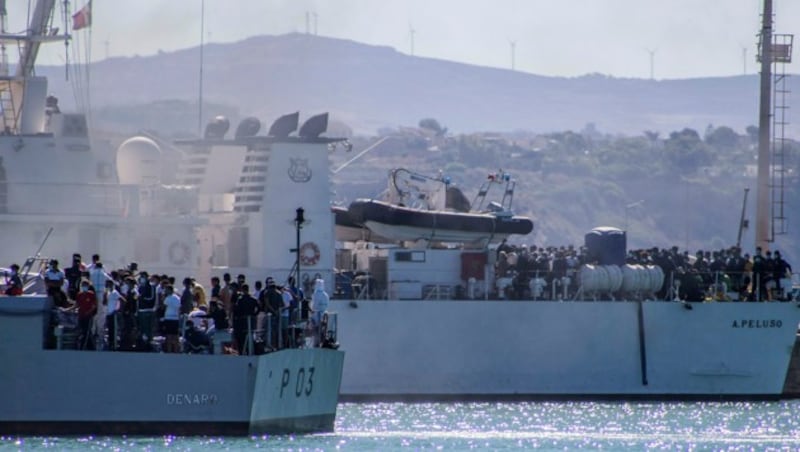 Migranten an Bord zweier Schiffe der italienischen Marine nahe der Insel Lampedusa (Bild: AP)