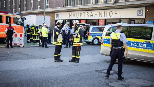Einsatzkräfte der Polizei stehen vor dem Hauptbahnhof in Düsseldorf. Alle Reisenden mussten das Bahnhofsgebäude verlassen. (Bild: APA/dpa/Marcel Kusch)