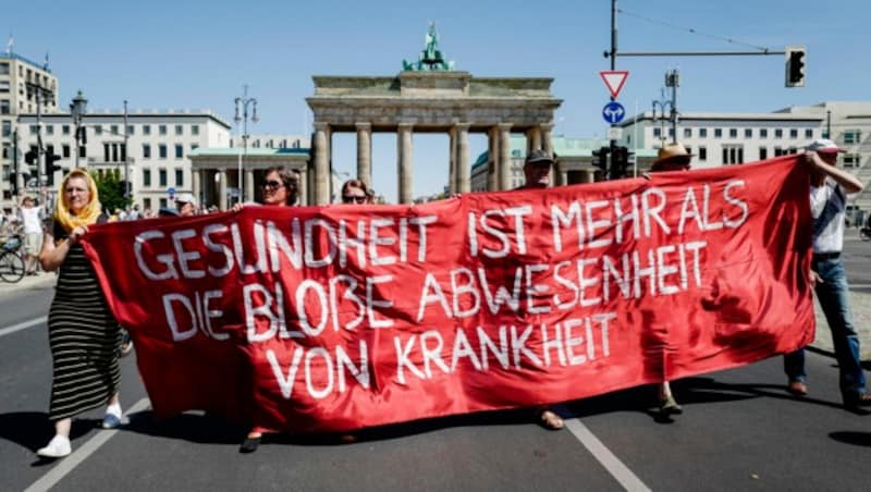 Mitglieder der Gruppierung „Querdenken 711“ spielen auf diesem Transparent bei der aufgelösten Demo in Berlin auf den Spruch „Frieden ist mehr als die bloße Abwesenheit von Krieg“ an. (Bild: AFP)