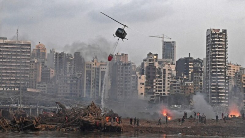 Ein Hubschrauber beim Versuch mehrere Brände nach der Explosion zu löschen. (Bild: AFP/Hasan Mroue)