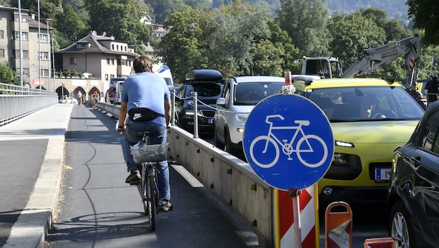 Ein Bild, das mehr als Worte die Verkehrszukunft Innsbrucks vorhersagt: Freie Fahrt für Radfahrer auf der Mühlauer Brücke, während Autofahrer im Stau stehen. (Bild: Andreas Fischer)