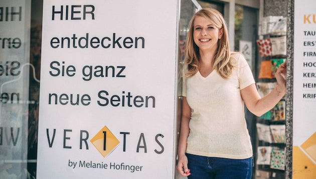 Melanie Hofinger mit ihrem Buchautomaten, der direkt neben dem Eingang zu ihrem Geschäft in der Harrachstraße in Linz aufgestellt wurde. (Bild: Veritas/Mathias Klugsberger)