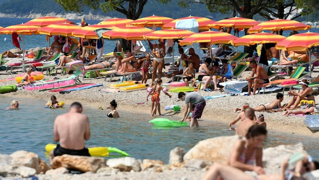 Sonnenschirm an Sonnenschirm an diesem Adria-Strand in Crikvenica - ab Mitternacht von Sonntag auf Montag gilt für Kroatien eine Reisewarnung. (Bild: AFP)