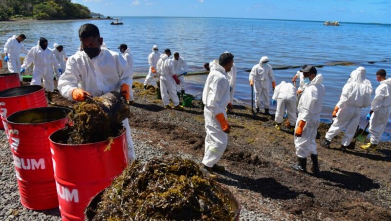 Freiwillige versuchen, Verschmutzungen vom Strand zu entfernen. (Bild: AFP)