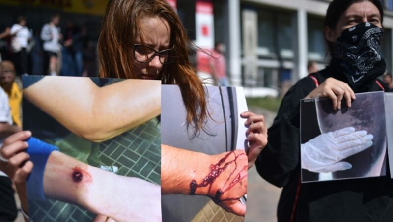 Bei einer Kundgebung in Minsk zeigen Demonstranten Bilder von Folteropfern. (Bild: AFP)