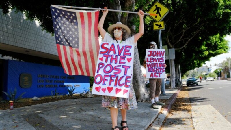 Demonstranten protestieren vor einer Postfiliale in Los Angeles gegen Änderungen des Betriebs. (Bild: AP)