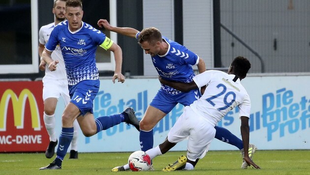 Trafen beim 2:0 in Grödig: Die FC Pinzgau-Spieler Tandari (Ii.) und Schubert (im blauen Dress) (Bild: Tröster Andreas)