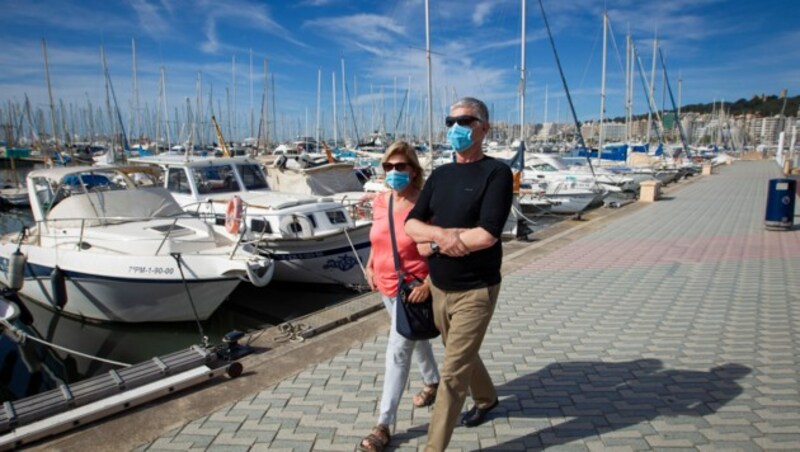 Touristen gehen am Hafen der mallorquinischen Hauptstadt Palma de Mallorca vorbei. (Bild: AFP)