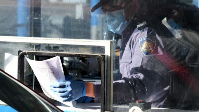 Ein kroatischer Polizeibeamter bei der Kontrolle Einreisender an der slowenisch-kroatischen Grenze in Bregana (Bild: AFP)