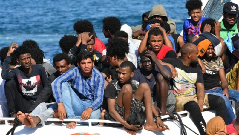 Migranten aus Tunesien und Libyen bei der Ankunft auf Lampedusa (Bild: AFP)