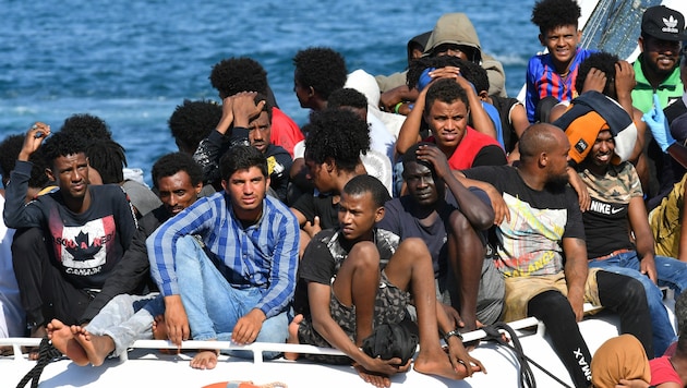 Migranten aus Tunesien und Libyen bei der Ankunft auf Lampedusa (Bild: AFP)