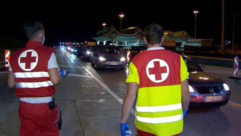 Mitarbeiter des Roten Kreuzes betreuten Autoinsassen in dem kilometerlangen Stau bei der Einreise am Karawankentunnel. (Bild: APA/ORF Kärnten)