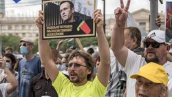 Ein Demonstrant hält ein Schild von Kreml-Kritiker Alexej Nawalny in die Höhe, auf dem steht: „Nawalny wurde vergiftet. Wir wissen, wer Schuld hat. Alexej, du musst leben.“ (Bild: AP)