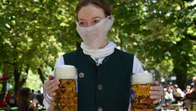 Eine Kellnerin mit Mundschutz in einem Münchner Biergarten (Bild: AFP)