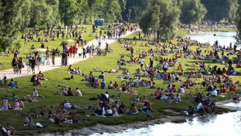 An einem schönen Sommertag versammeln sich Tausende Münchner am Ufer der Isar. (Bild: AP)