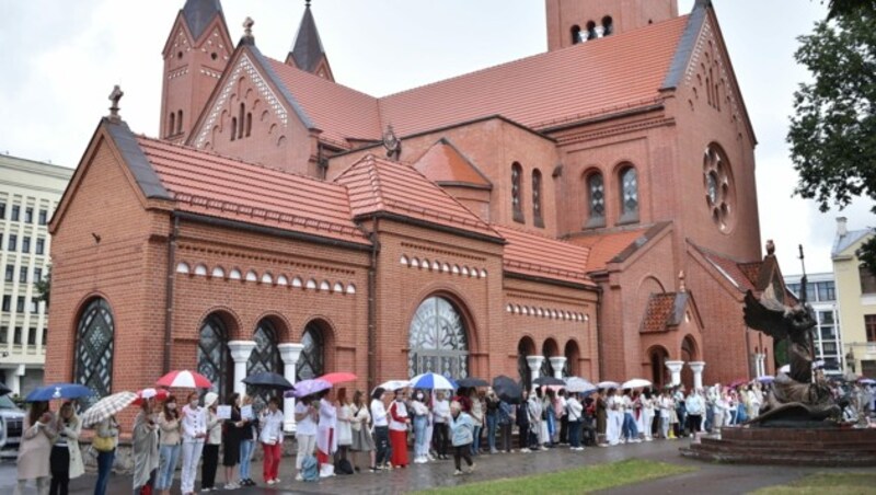 Frauen bilden eine Menschenkette außerhalb der katholischen St.-Simons-Kirche in Minsk. (Bild: APA/AFP/Sergei GAPON)