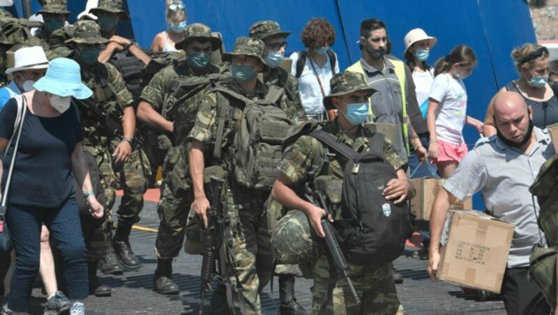 Griechische Soldaten verlassen gemeinsam mit Touristen eine Fähre auf der Insel Kastellorizo (Megisti). Das Eiland ist die südöstlichste bewohnte Insel Griechenlands und nur zwei Kilometer von der Küste der Türkei entfernt. (Bild: Louisa GOULIAMAKI/AFP)