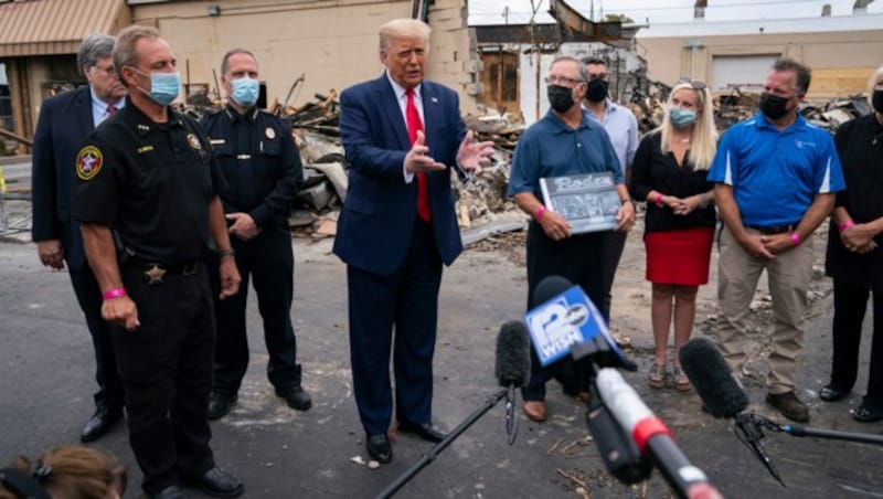 US-Präsident Donald Trump in Kenosha vor einem Gebäude, das bei den Ausschreitungen zerstört wurde (Bild: AP)