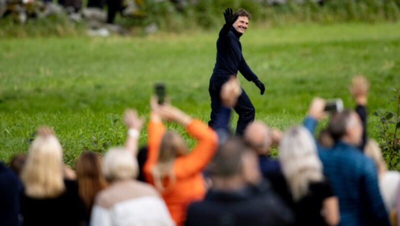 Tom Cruise nahm sich nach dem Mega-Stunt kurz Zeit für die Zaungäste, die das Spektakel beobachtet hatten. (Bild: AFP)