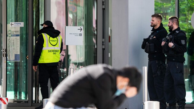 Polizisten und ein Sicherheitsmitarbeiter stehen vor dem Haupteingang der Berliner Charité. Um ein neuerliches Attentat auf den Kreml-Kritiker zu verhindern, sind die Sicherheitsmaßnahmen zuletzt weiter verstärkt worden. (Bild: APA/dpa/Bernd von Jutrczenka)